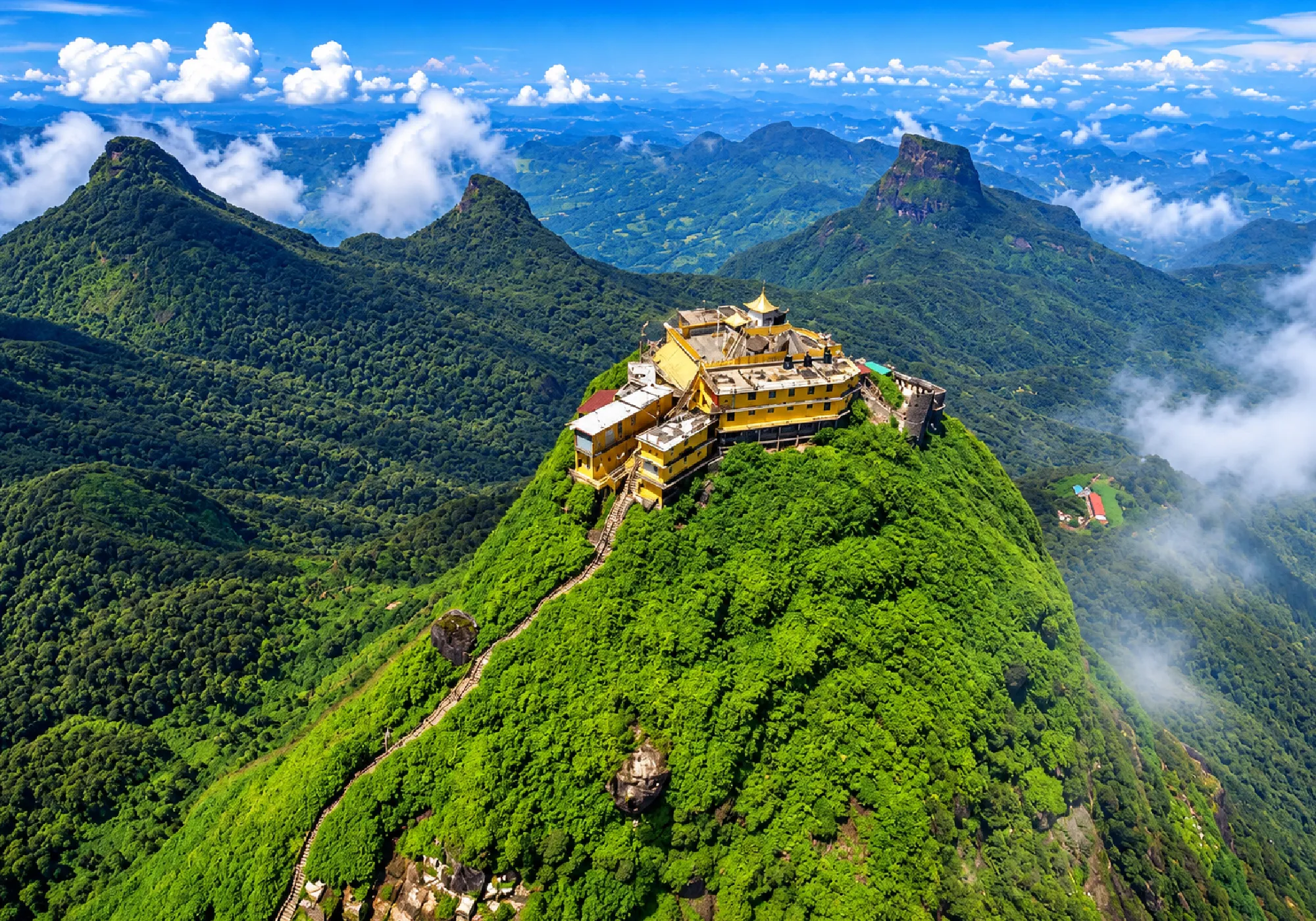 Sigiriya Lion Rock fortress surrounded by lush green mountains and misty landscapes in Sri Lanka
